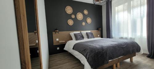 une chambre avec un lit et des miroirs au mur dans l'établissement Le Cerf au Bois Dormant, à Ruelle-sur-Touvre