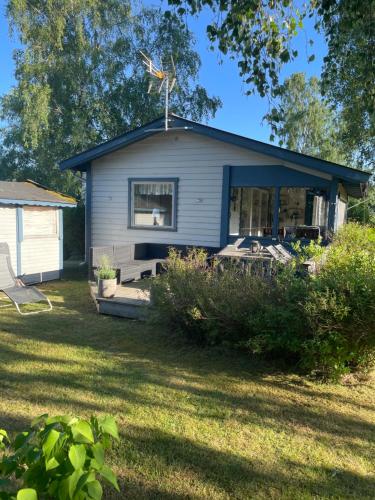 a small house with a window and a yard at Stuga på västkusten mellan Halmstad och Båstad in Laholm