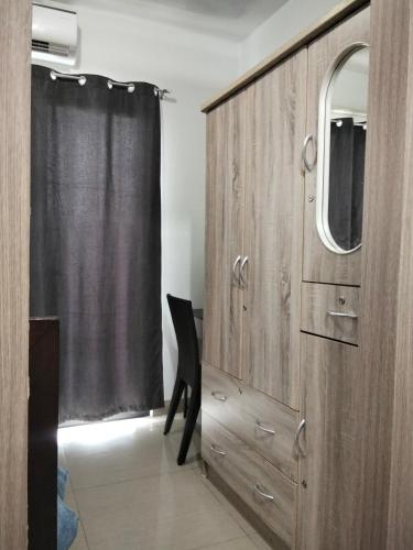 マニラにあるVSV Luxury Family Suite staycation Moa shore2 tower2 unit 1122の鏡と椅子が備わる木製のキャビネット