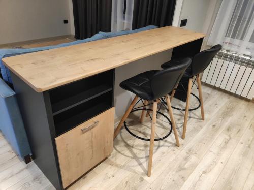 a wooden desk with two chairs in a room at Apartment for rent number 3 in Aktau