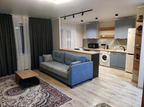 a living room with a blue couch and a kitchen at Apartment for rent number 3 in Aktau
