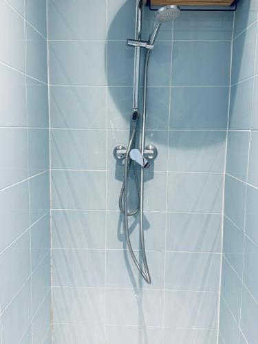 La salle de bains est pourvue d'une douche et de carrelage bleu. dans l'établissement Le Refuge Bohème, à Paris