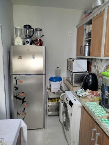 a kitchen with a refrigerator and a microwave at Apto Pedreira para círio e cop30 in Belém