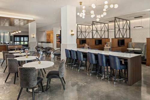 a restaurant with tables and chairs and a bar at Courtyard by Marriott St Paul Downtown in Saint Paul