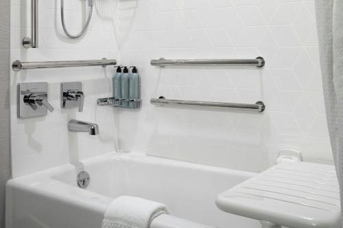 a bathroom with a white tub and a toilet at Courtyard by Marriott St Paul Downtown in Saint Paul