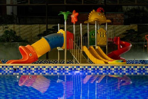 a childrens playground with a pool of water at Sunny Garden Riverside Hotel Ninh Binh in Ninh Binh
