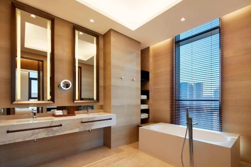 a bathroom with a tub and a sink and mirror at Aloft Seoul Myeongdong in Seoul
