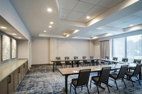 a conference room with tables and chairs and a large window at Delta Hotels by Marriott Jacksonville Deerwood in Jacksonville