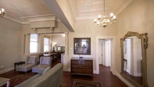 Una sala de estar con un sofá y un espejo. en Villa Antica, en Ciudad del Cabo