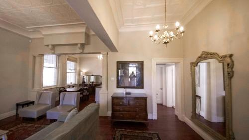 Una sala de estar con un sofá y un espejo. en Villa Antica, en Ciudad del Cabo