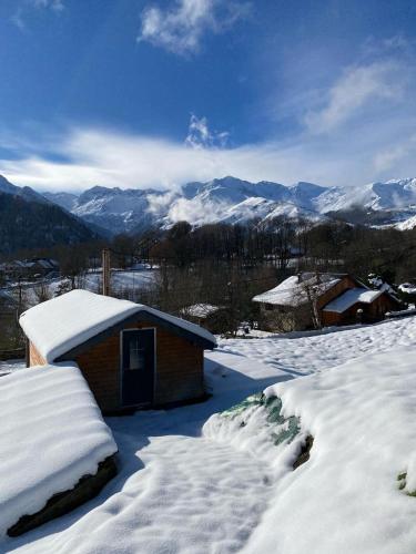 a small building covered in snow with mountains in the background at Chalet séduisant in Garin