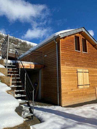 a wooden building with stairs in the snow at Chalet séduisant in Garin
