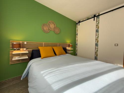 a bedroom with a large bed with a green wall at Modern & sunny beach apartment in Fuengirola