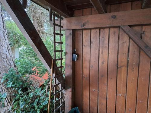 a wooden garage door with a ladder next to a tree at Mino Apartment in Bludenz