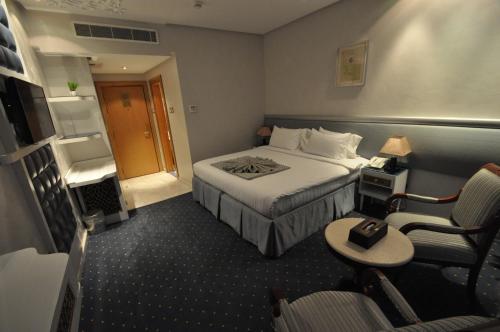 a hotel room with a bed and a chair at Montana Al Azizia Hotel in Makkah
