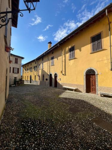 a cobblestone street in front of a yellow building at Campidoglio vacation home in Lenno