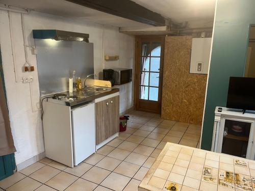 une cuisine avec un réfrigérateur blanc et un évier dans l'établissement Studio le petit Bouclet, au Tréport