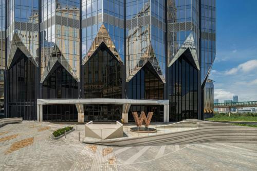 a view of a tall glass building with a fountain at W Macau - Studio City in Macau