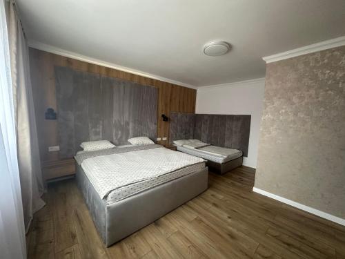a bedroom with two beds and wooden floors at Country house Egomer in Călugări