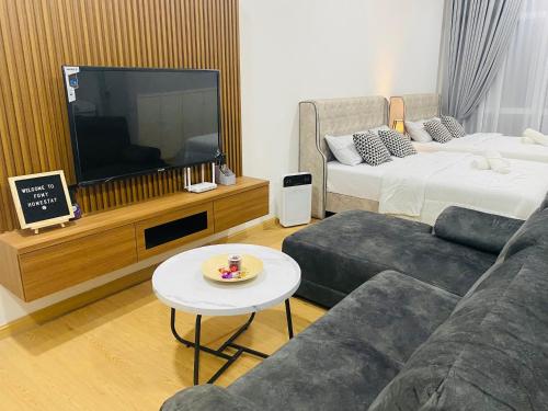 a living room with a couch and a tv at FUMY Homestay in Kuantan