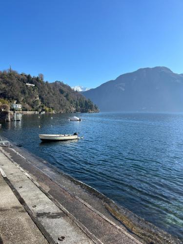 a boat in the water next to a beach at Campidoglio vacation home in Lenno