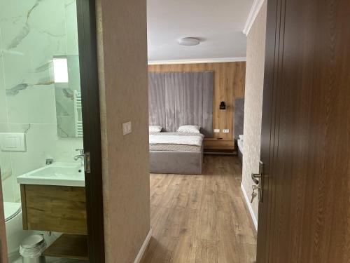 a bathroom with a sink and a bed in a room at Country house Egomer in Călugări