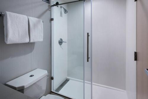 a bathroom with a shower and a toilet at Courtyard Newburgh Stewart Airport in Newburgh