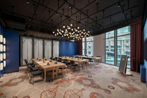 a conference room with tables and chairs and windows at W Macau - Studio City in Macau