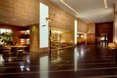 a lobby of a hotel with tables and chairs at Renaissance São Paulo Hotel in Sao Paulo