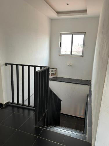 a room with a staircase and a window at Three bedroom luxurious house "Owusu- ansah transformer" in Pantang