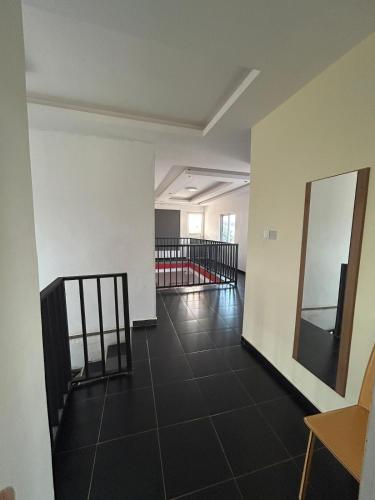 an empty room with a staircase and a mirror at Three bedroom luxurious house "Owusu- ansah transformer" in Pantang