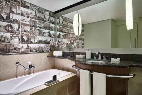 a bathroom with a tub and a sink and a mirror at Renaissance São Paulo Hotel in Sao Paulo