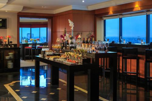 a restaurant with a bar with glasses on a table at Renaissance São Paulo Hotel in Sao Paulo
