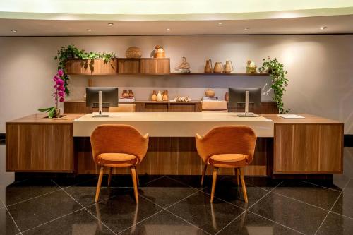 a lobby with two chairs and a reception desk at Renaissance São Paulo Hotel in Sao Paulo
