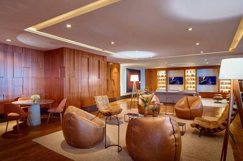 a living room with leather chairs and a table at Renaissance São Paulo Hotel in Sao Paulo