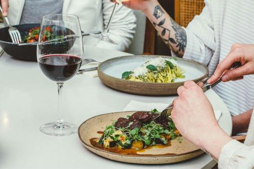 a table with a plate of food and a glass of wine at Renaissance São Paulo Hotel in Sao Paulo