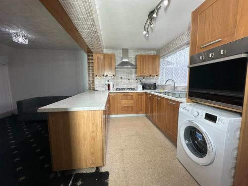 una cocina con lavadora y lavadora en 3 Bedroom House Available, en Hounslow