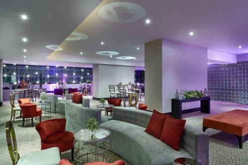 a lobby with a couch and chairs and tables at Renaissance São Paulo Hotel in Sao Paulo