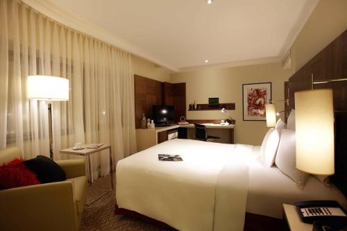 a hotel room with a large white bed and a couch at Renaissance São Paulo Hotel in Sao Paulo