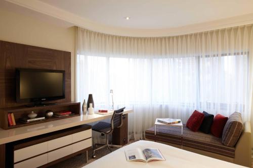 a hotel room with a television and a desk with a bed at Renaissance São Paulo Hotel in Sao Paulo