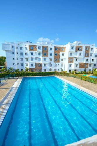 una piscina di fronte a un edificio di Stylish 2 Bedroom Apt Mombasa Pool, Gym, AC, Secure and Central a Mombasa