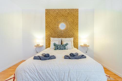 a bedroom with a large bed with towels on it at Tropical nest - Taverny - Ligne H in Taverny