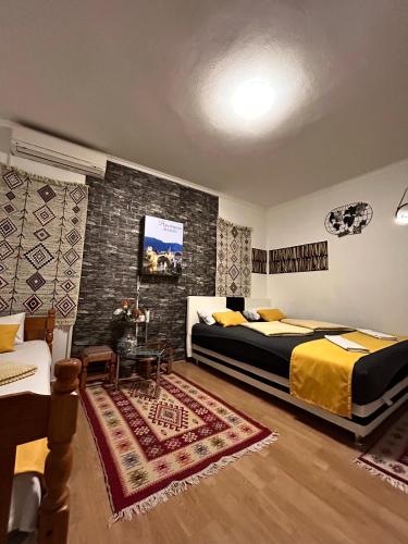 a bedroom with two beds and a table in it at Apartments Mehić in Mostar