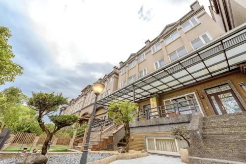 a large building with a staircase in front of it at 宜蘭小綠丘民宿 in Luodong