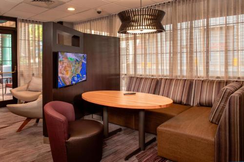 a waiting room with a table and a couch at Courtyard Wilmington Downtown in Wilmington