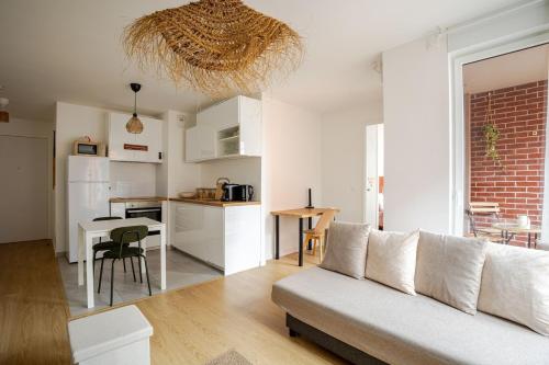 un salon et une cuisine avec un canapé et une table dans l'établissement 2 room apartment near PARIS, à Bagneux
