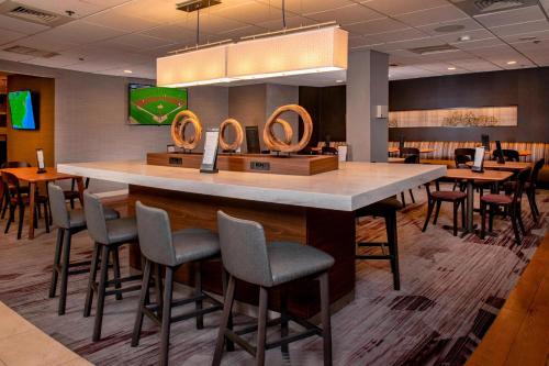 a bar in a restaurant with chairs and tables at Courtyard Wilmington Downtown in Wilmington