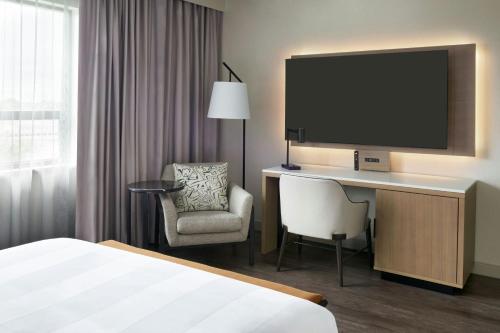 a hotel room with a bed and a desk with a television at Kingston Marriott Hotel in Kingston