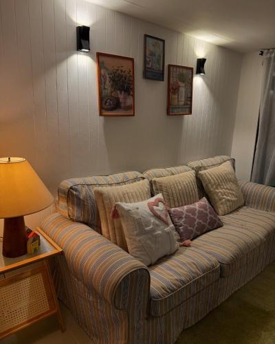a couch with pillows on it in a living room at Tiny Escape Charlotte in Pak Chong