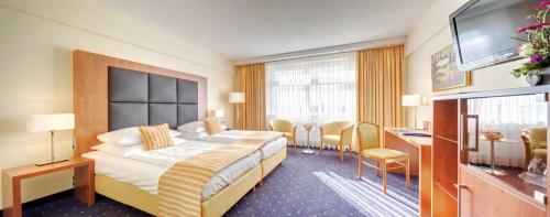 a hotel room with a bed and a television at Best Western Plus Hotel Steinsgarten in Gießen